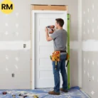 Contractor installing a solid wood and hollow core door in Toronto home renovation